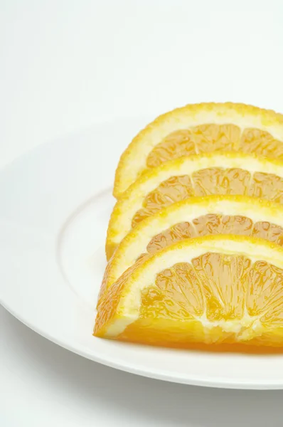 Оранжевые ломтики, расположенные в тарелке — стоковое фото