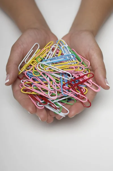 Vrouwelijke handen met veelkleurige paperclips — Stockfoto