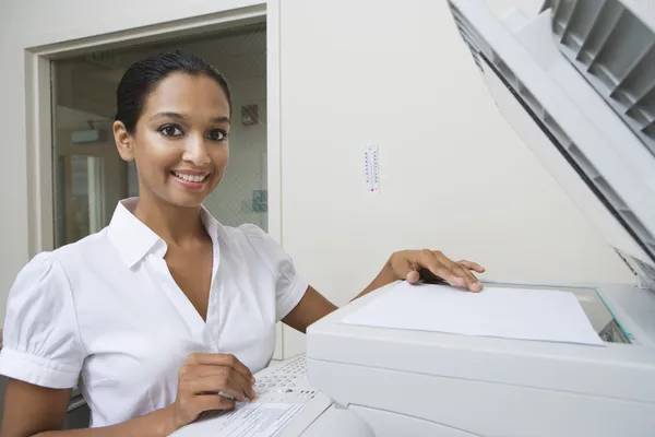 Szczęśliwa kobieta za pomocą faksu w biurze — Zdjęcie stockowe