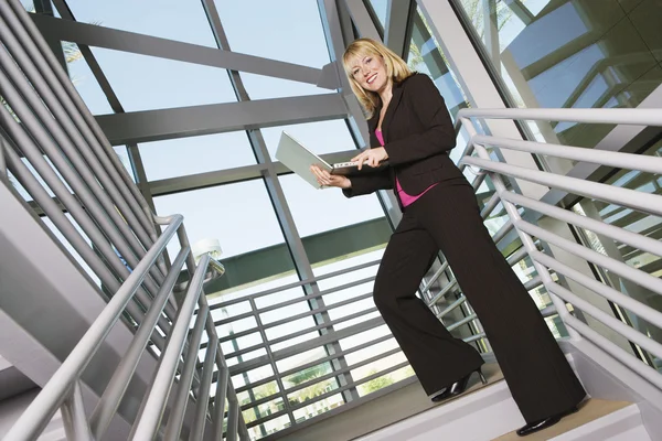 Merdiven üzerinde dizüstü kullanarak iş kadını — Stok fotoğraf