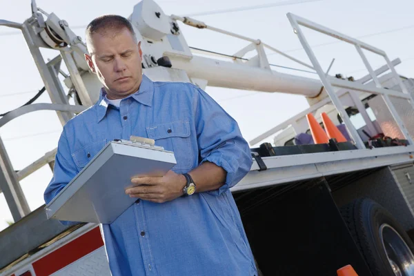Mechanic Writing Notes On Clipboard Against A Truck — Stock Photo, Image