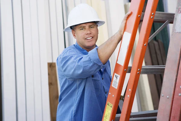 Trabajador industrial parado junto a una escalera — Foto de Stock