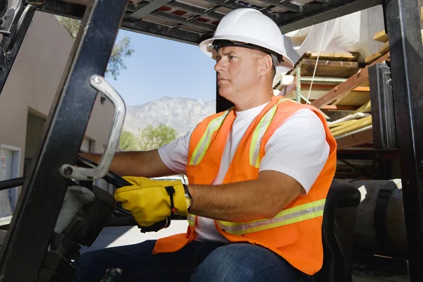 Carretilla elevadora de conducción de trabajadores seguros en el lugar de trabajo — Foto de Stock