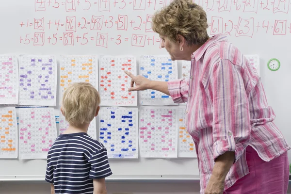 Teacher Explaining Calendar To Little Boy — Stock Photo, Image