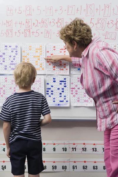 Учитель объясняет календарь маленькому мальчику — стоковое фото
