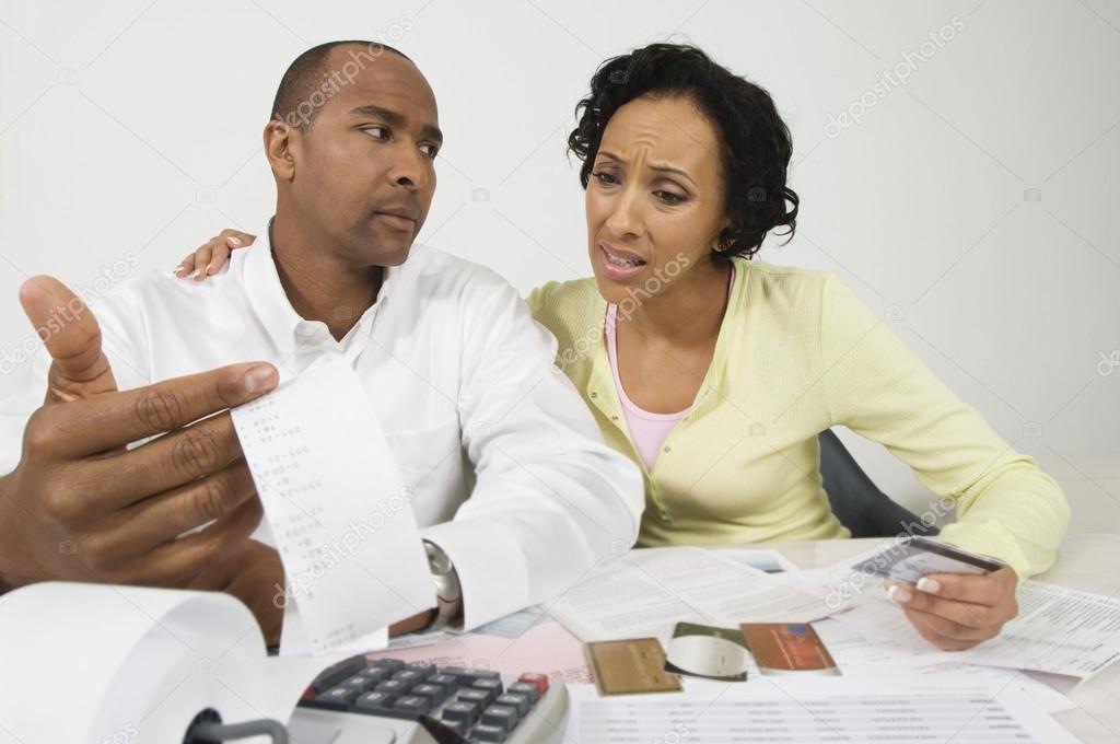Worried Couple With Expense Receipt And Credit Cards