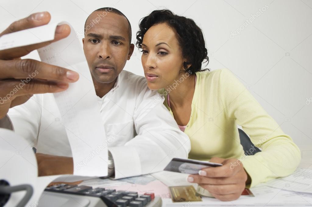 Couple Looking At Expense Receipt At Home