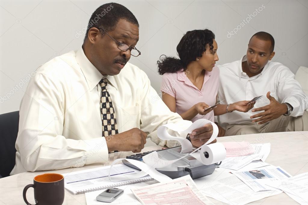 Financial Advisor Holding Expense Receipt With Couple In The Background