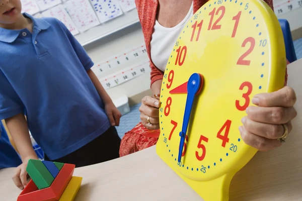 Enseignant montrant du temps aux enfants — Photo