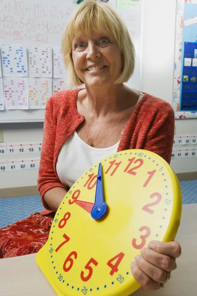Insegnante che tiene un orologio di insegnamento del tempo — Foto Stock