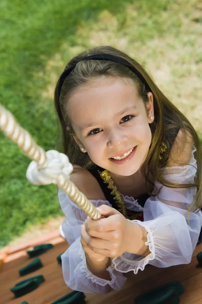 Klädde upp liten flicka klättring ett rep — Stockfoto