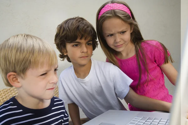 Concerned kids with laptop — Stock Photo, Image