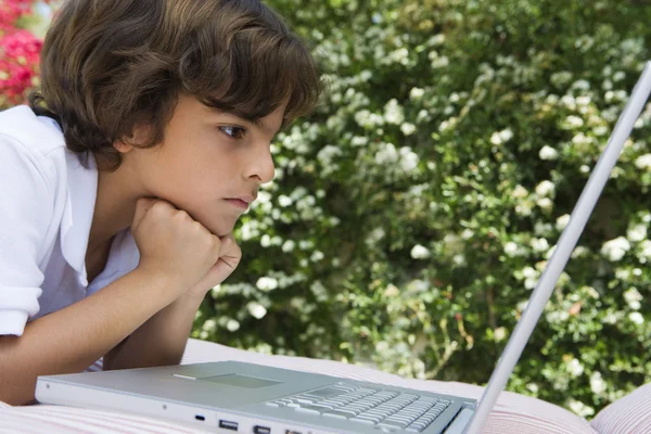 Junge schaut auf Laptop — Stockfoto