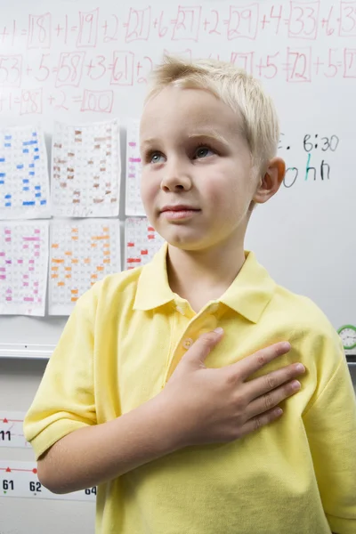 Skolpojke med sin hand över hjärta — Stockfoto