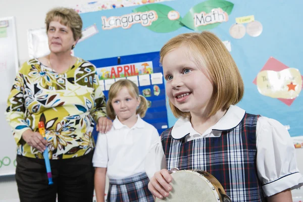 Elementära student med tamburin i musik klass — Stockfoto