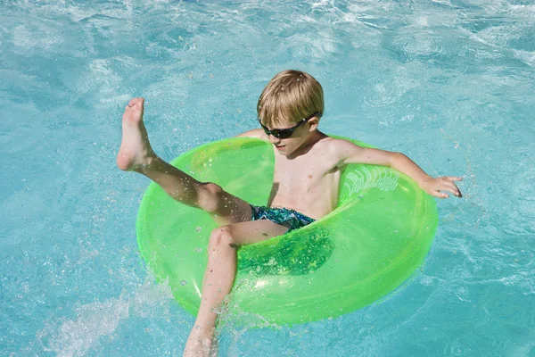 Мальчик на плавучем метро в бассейне — стоковое фото