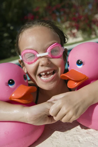 Menina feliz com patos de plástico na piscina — Fotografia de Stock