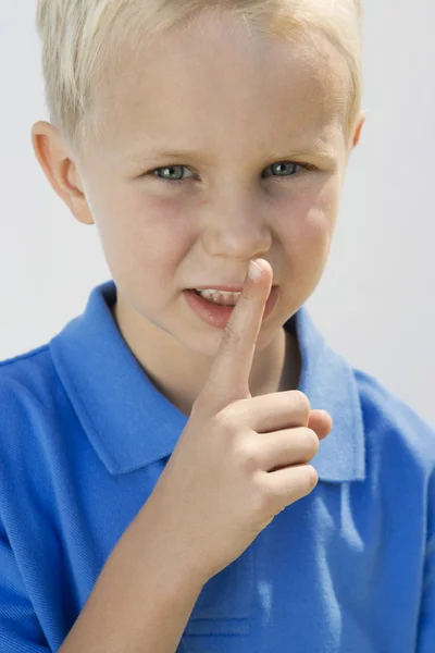 Мальчик с пальцем на губах — стоковое фото