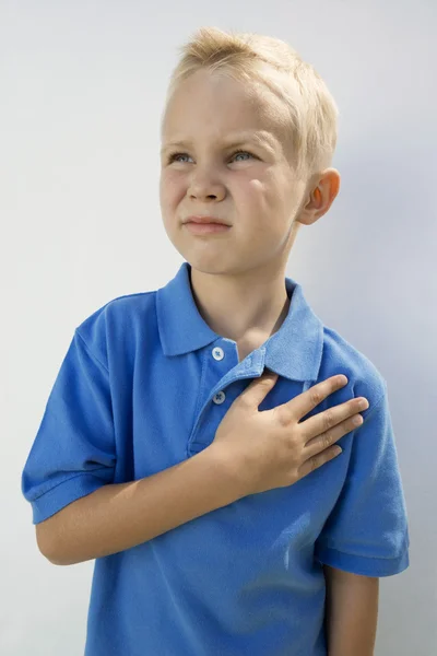 Junge mit der Hand am Herzen — Stockfoto