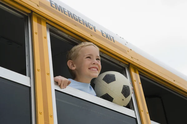 Liten pojke med fotboll i skolbussen — Stockfoto