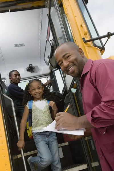 Lärare lossning elementära studenter från skolbuss — Stockfoto