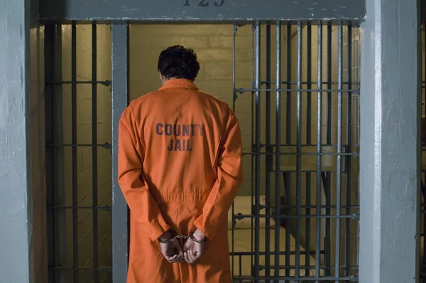 Мужчина в наручниках в тюрьме — стоковое фото