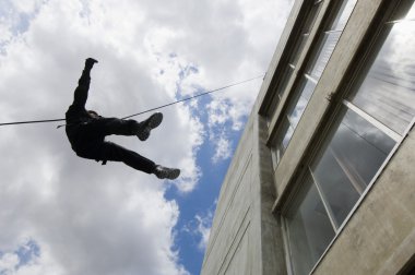 SWAT Team Officer Rappelling from Building clipart
