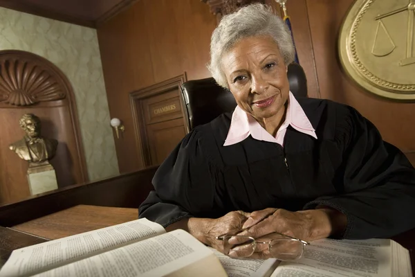 Juge féminine assise avec des livres de droit — Photo