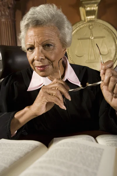 Senior vrouwelijke rechter zitten met boeken — Stockfoto