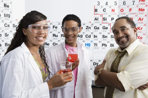 Учитель со студентами в научной лаборатории — стоковое фото