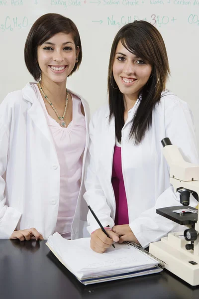 在科学实验室的显微镜下的女学生 — 图库照片