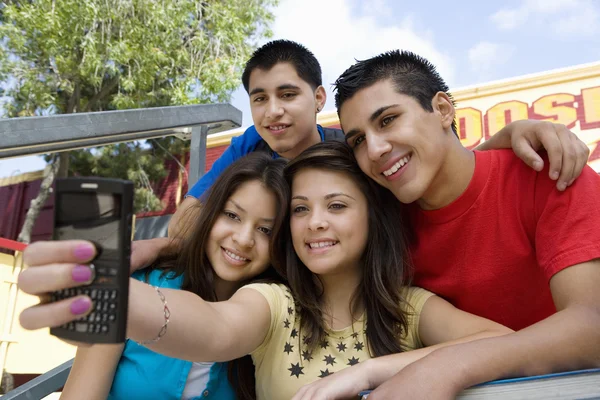 Друзья из старшей школы фотографируют себя с помощью мобильного телефона — стоковое фото