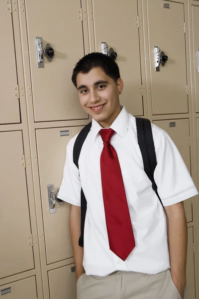 Middelbare school jongen permanent door kluisjes — Stockfoto