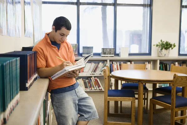 Студент учится в библиотеке — стоковое фото