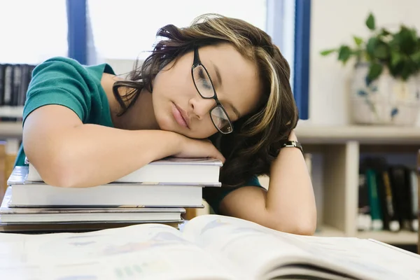 High schoolstudent slapen op een stapel boeken — Stockfoto