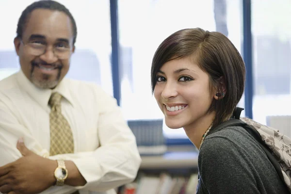 Professor met vrouwelijke student in bibliotheek — Stockfoto