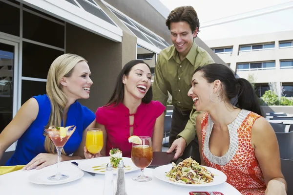 Camarero trayendo cheque a mujeres en restaurante — Foto de Stock