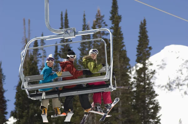 Üç kayakçı sandalye lift üzerinde — Stok fotoğraf