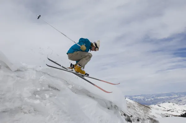 Лыжница прыгает с ледяного навеса — стоковое фото