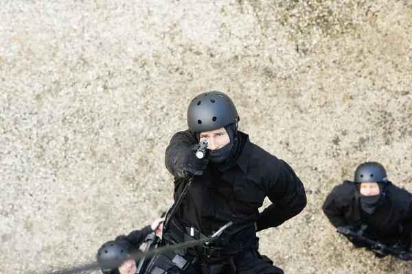 SWAT team officer rappelling och sikte pistol — Stockfoto