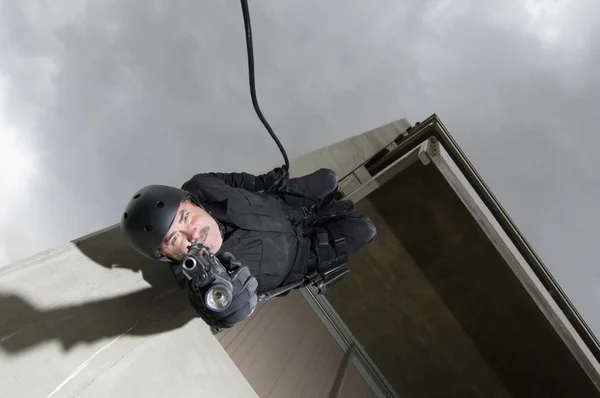 SWAT team officer rappelling och sikte pistol — Stockfoto