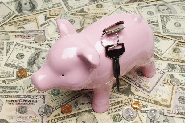 Piggy bank met toetsen op dollarbiljetten — Stockfoto