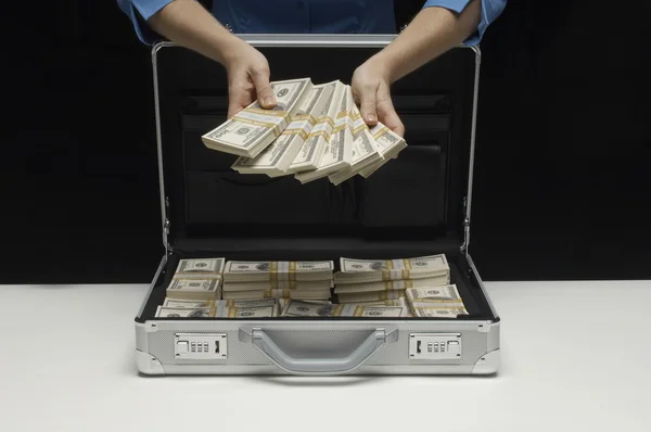 Kobieta z walizką Wyświetlono wiązki banknotów — Zdjęcie stockowe