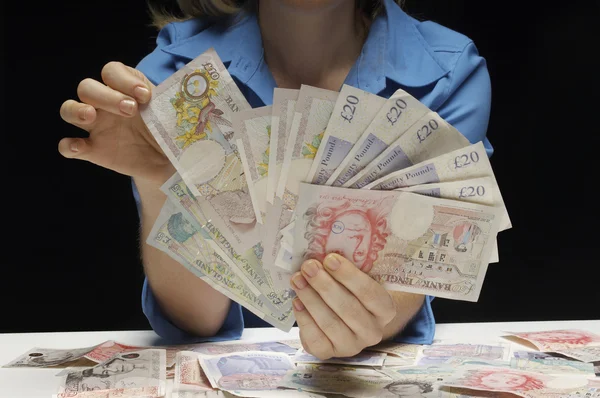 Vrouw met fan van pond bankbiljetten — Stockfoto