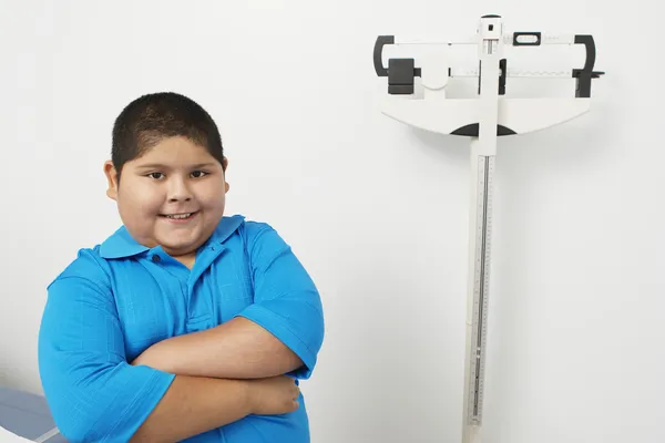 Niño de pie por balanza de pesaje en la clínica — Foto de Stock