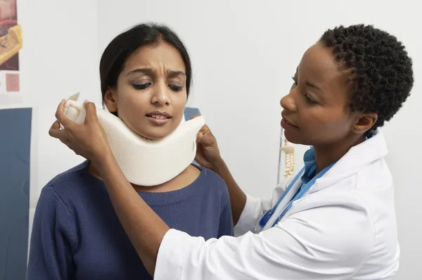 Doctora poniendo aparato ortopédico en el cuello del paciente — Foto de Stock