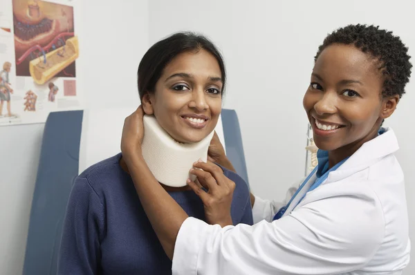 Médico feminino colocando cinta no pescoço do paciente — Fotografia de Stock