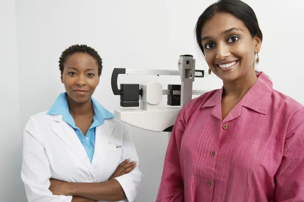 Porträt von Arzt und Patient mit Waage im Hintergrund — Stockfoto