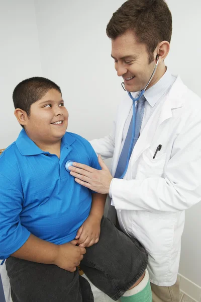 Doctor Listening To Boy 's Heartbeat — стоковое фото