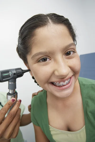 Mão verificando a orelha da menina feliz com otoscópio — Fotografia de Stock